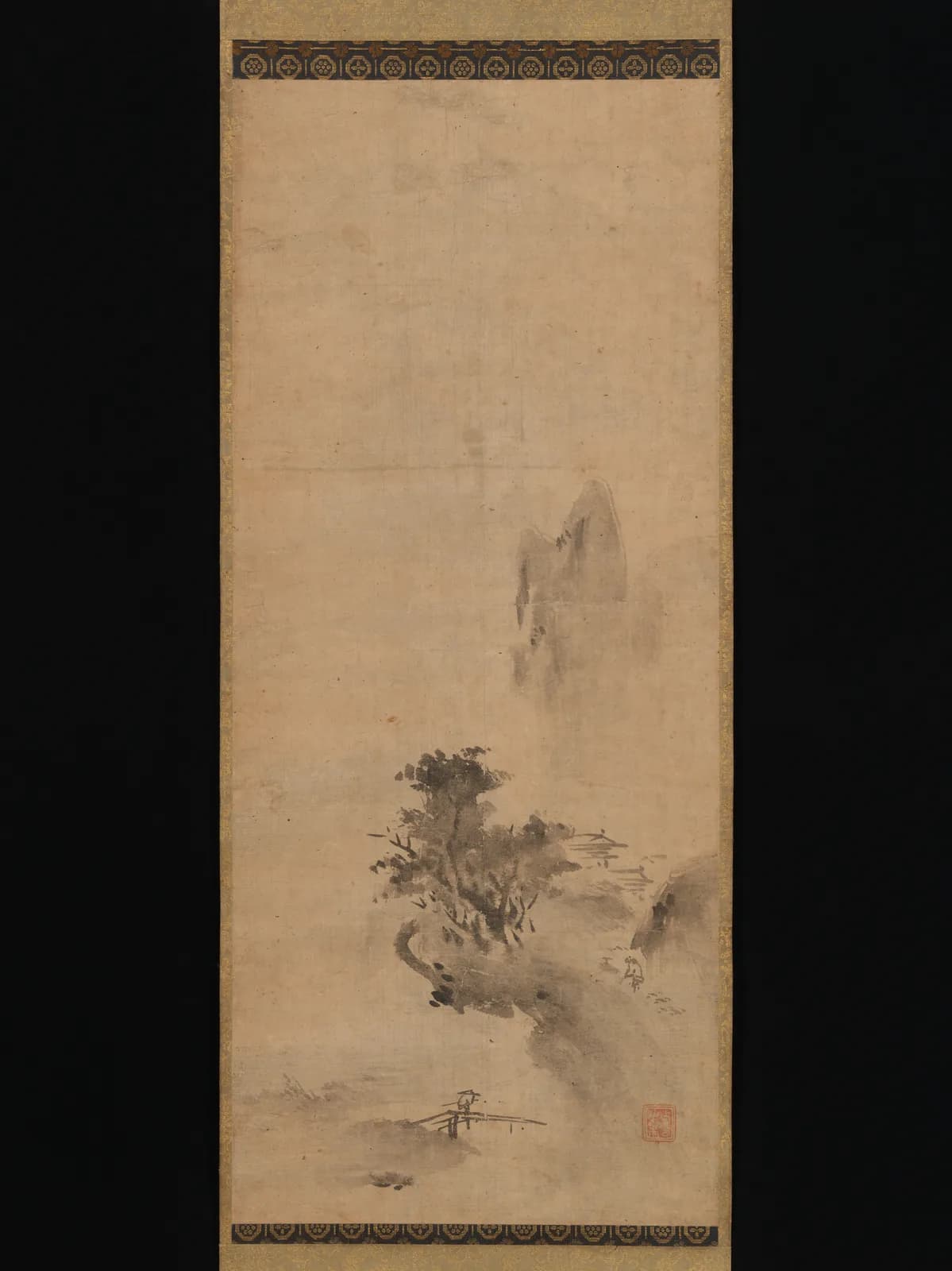 縦長の紙に、濃淡のにじむ墨で山、樹木、建物を簡略に描き、上部と周囲へ広い余白を残した水墨山水