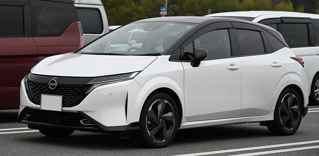 日産ノート オーラを斜め前から。黒いルーフを持つ白いコンパクトカー