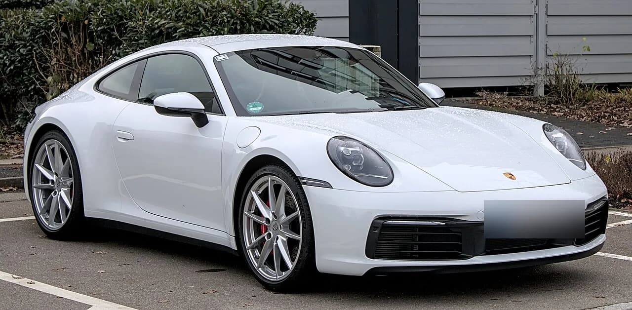 現行ポルシェ911（992型）を斜め前から。白いクーペ