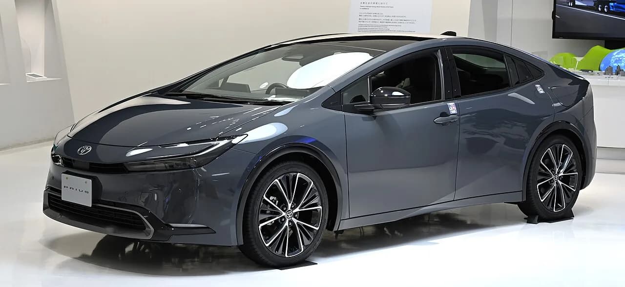 展示された現行型トヨタ・プリウスを斜め前から。低いルーフラインの濃いグレーのハッチバック