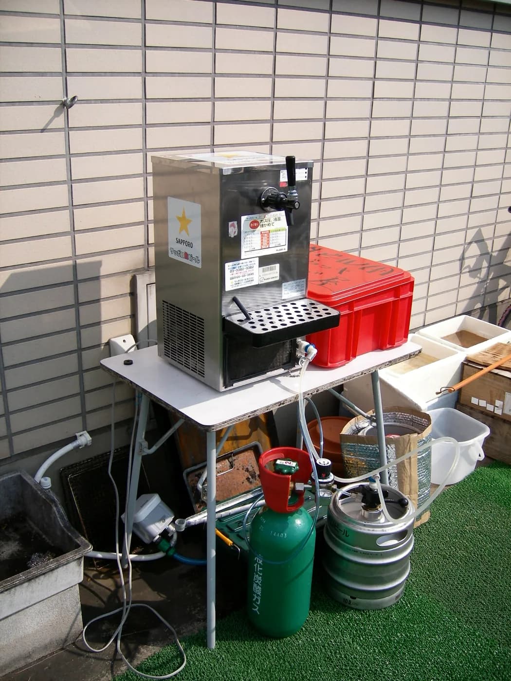 サッポロの卓上ビールサーバーと、緑色の炭酸ガスボンベ、ステンレスの樽