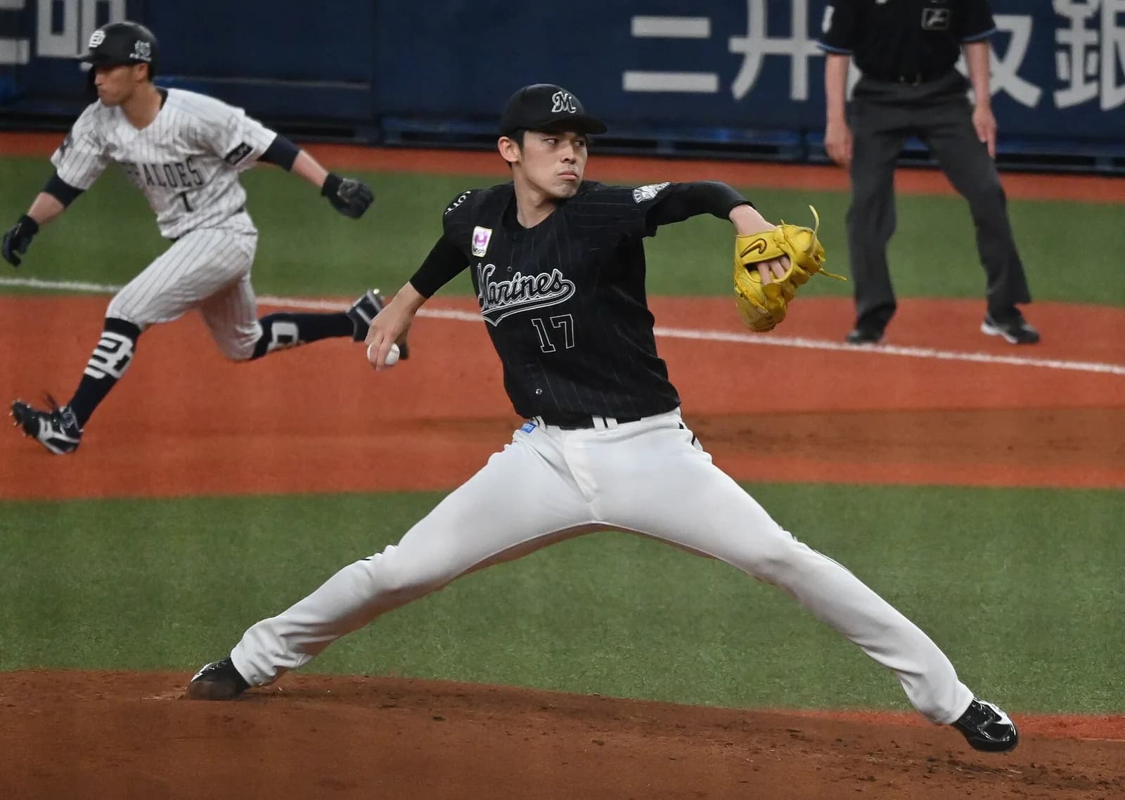 黒いユニフォームに背番号17の長身の投手が、マウンドから投げ込んでいる。後ろにオリックスの走者が見える