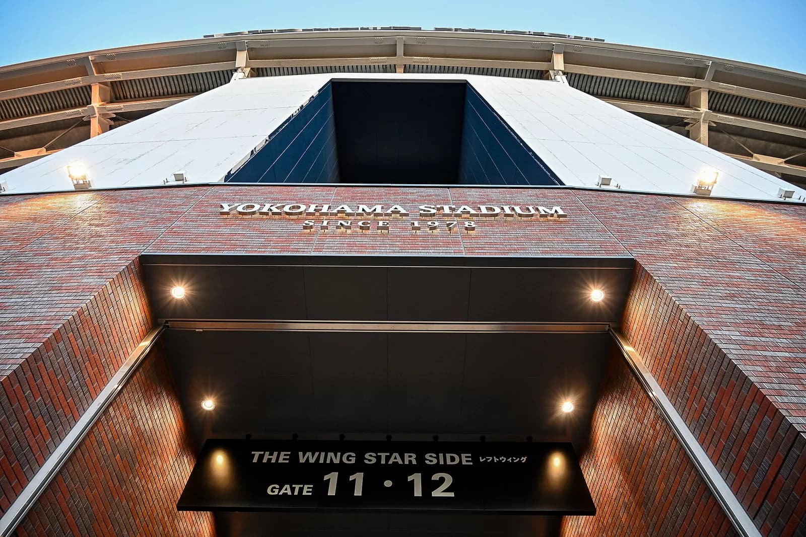レンガ張りの球場外壁を見上げた構図。YOKOHAMA STADIUM SINCE 1978の文字と、入場ゲートの案内板