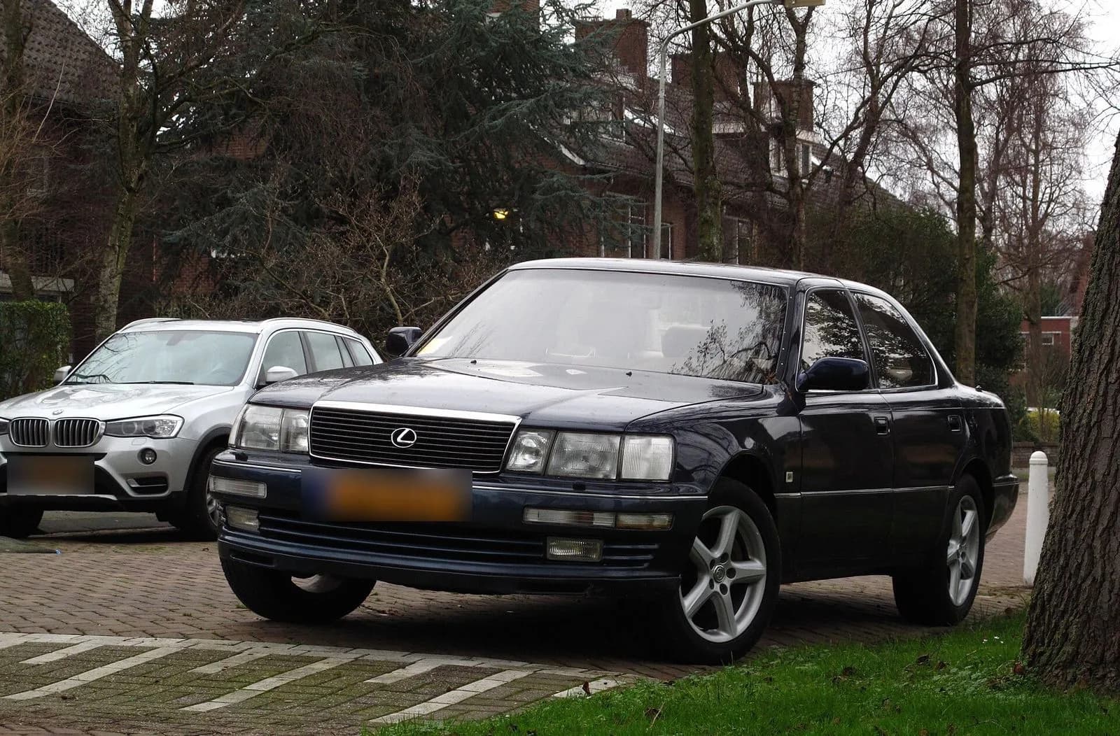 初代レクサスLS400(1994年型)を斜め前から。濃紺の大型セダン。左後方に別の車が並ぶ