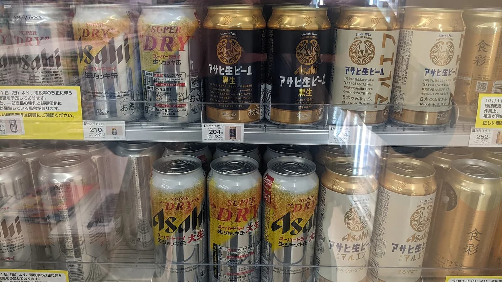 コンビニの冷蔵ケースのビール棚。スーパードライやアサヒ生ビールの缶が値札とともに並ぶ