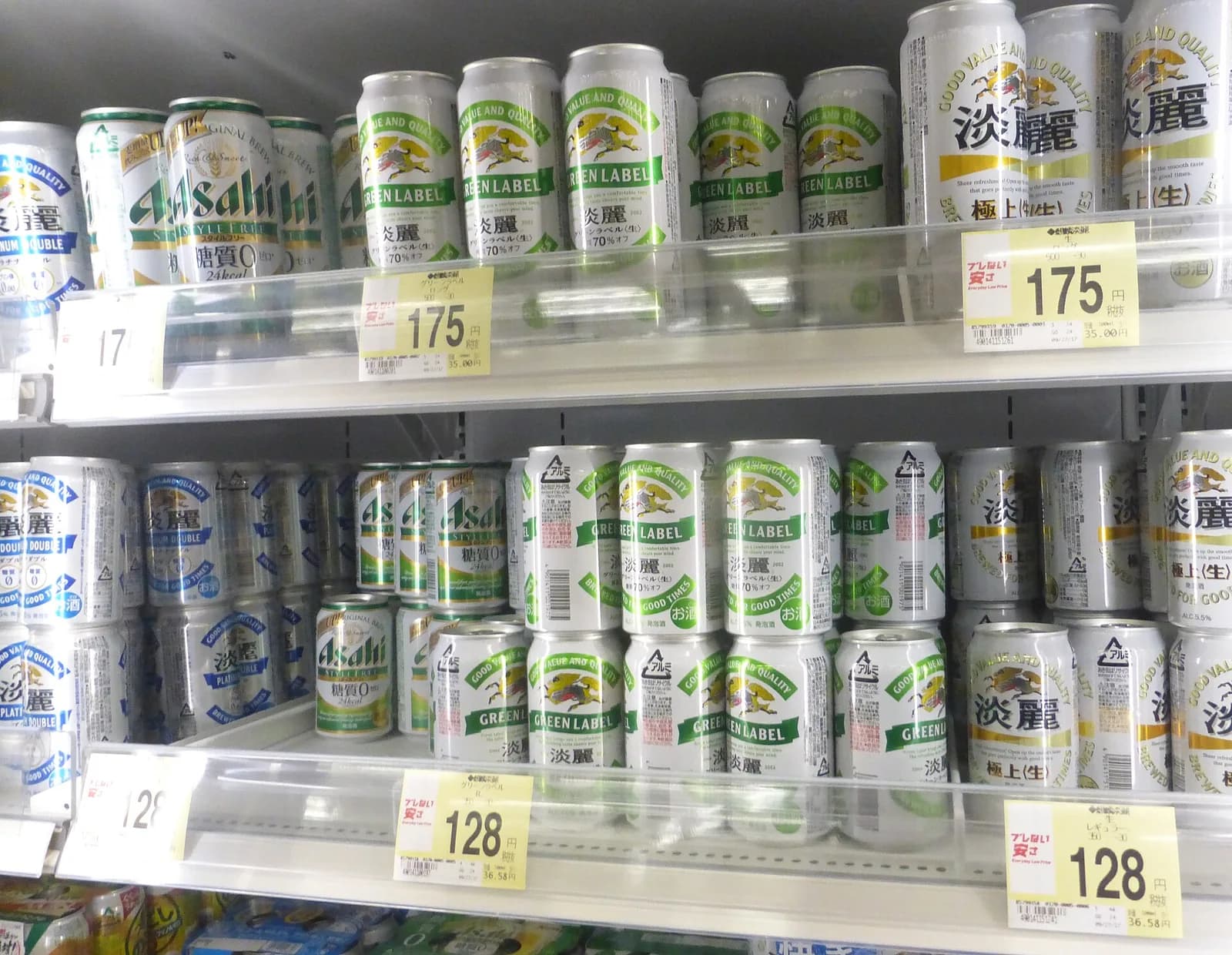 スーパーの棚に並ぶ発泡酒の缶。淡麗やグリーンラベルなどが値札とともに並ぶ