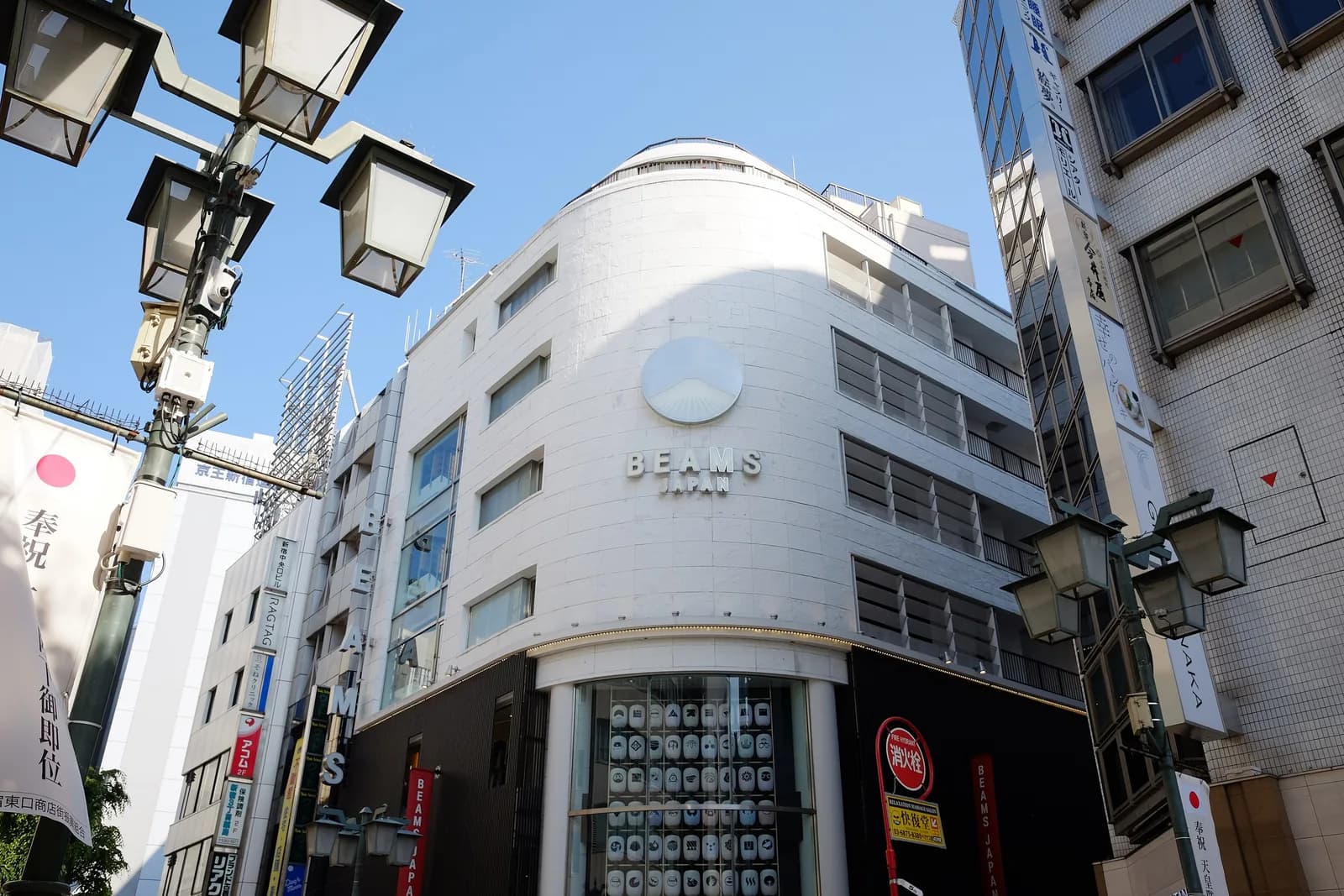 新宿のビームス ジャパンの外観。曲面の白い建物に円形のロゴとBEAMS JAPANの文字