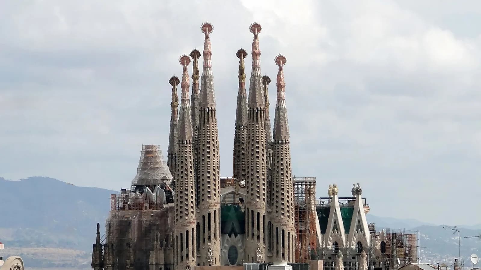 バルセロナのサグラダ・ファミリア。複数の尖塔が空に伸び、装飾の細かい生誕のファサードが見える