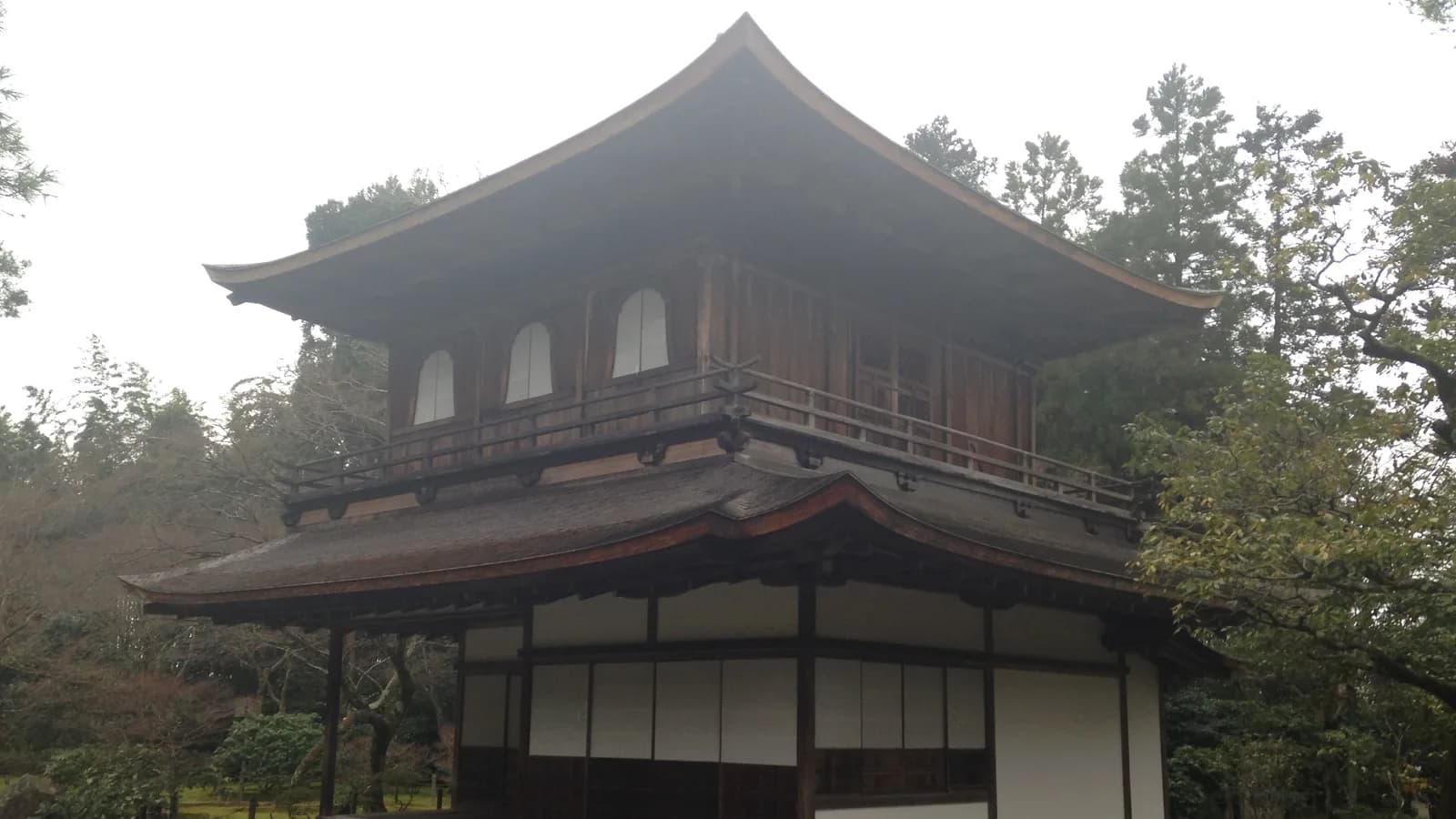 銀閣寺の観音殿。下の階は障子と縁側のある住宅風、上の階は板張りに花頭窓が並ぶ二階建て