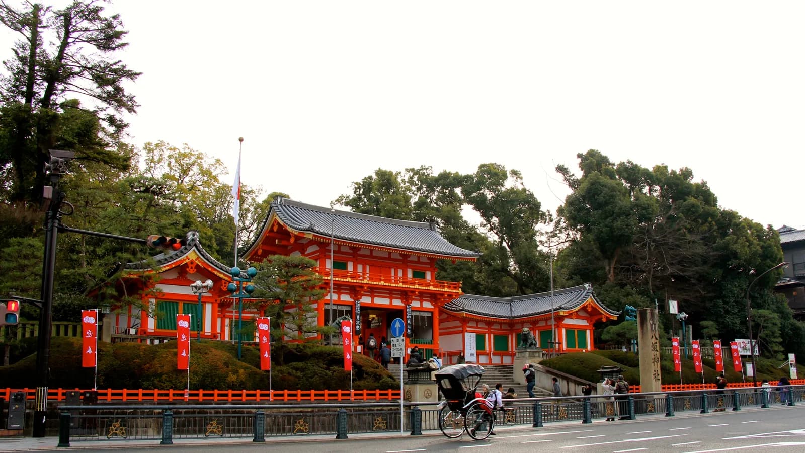 八坂神社の朱塗りの西楼門。石段の上に建ち、前を大きな通りが横切っている