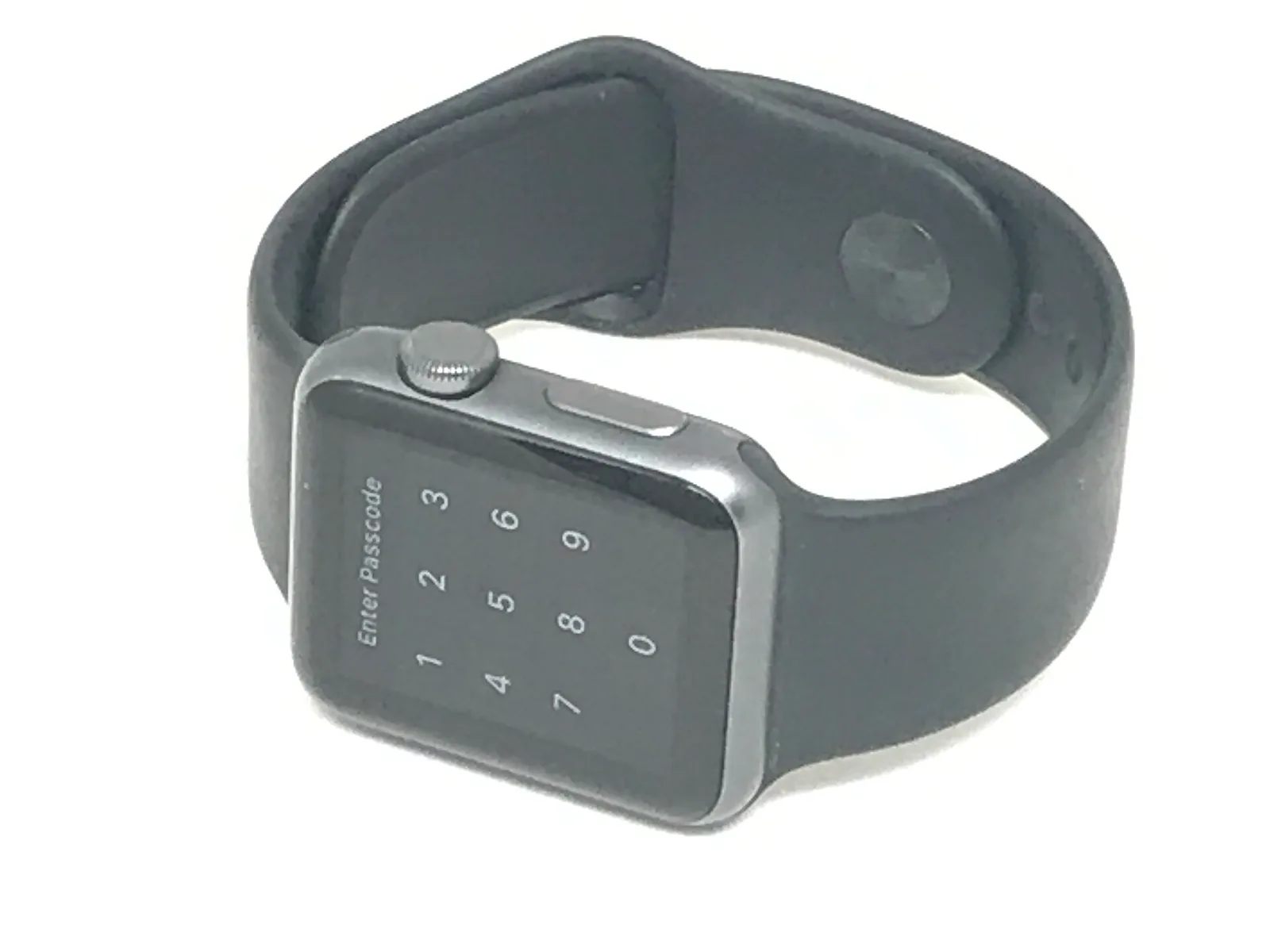 黒いスポーツバンドを付けた初代Apple Watch。画面にパスコードの入力画面が表示されている。白い背景